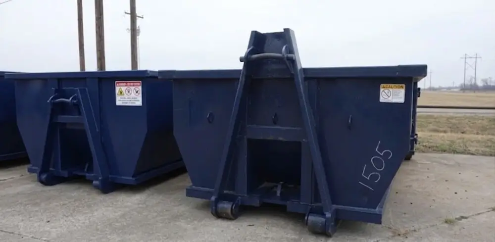 Empty roll-off dumpsters lined up in lot