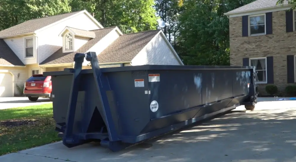 Navy dumpster parked in residential driveway