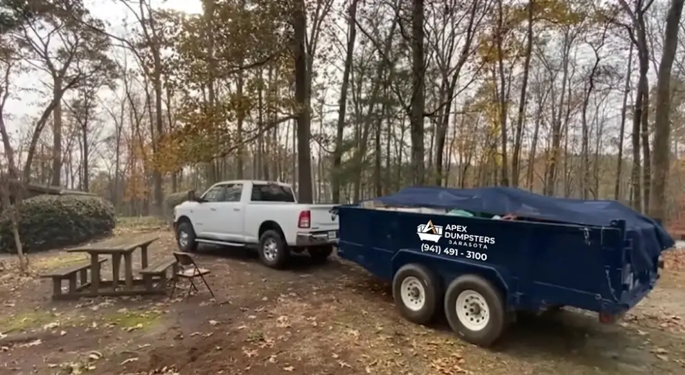Pickup truck towing small dumpster trailer