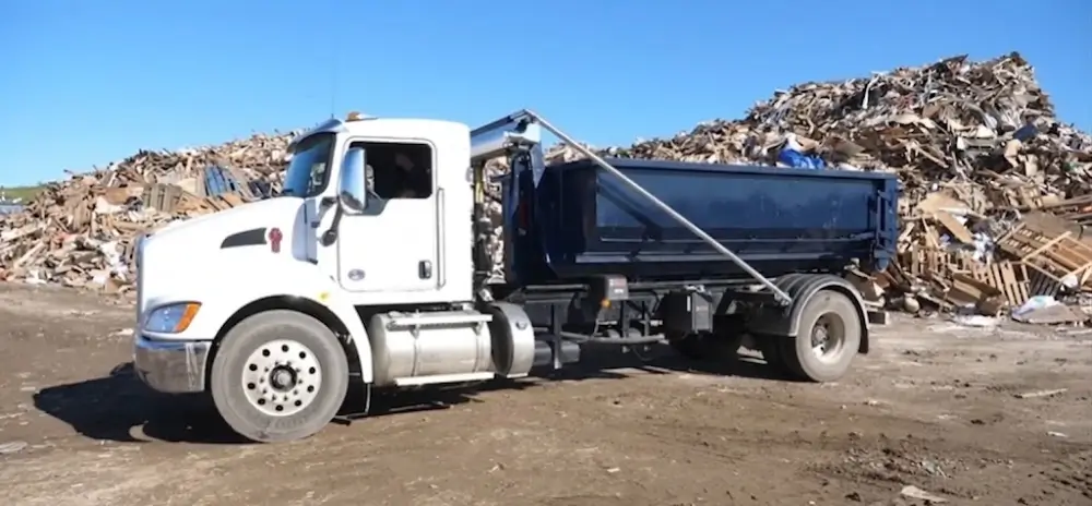 Roll-off dumpster truck at recycling facility